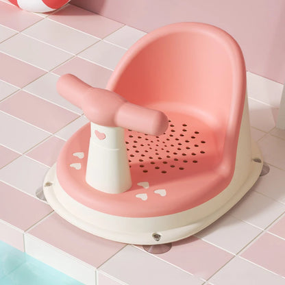 Pink Comfy Baby Bath Seat on tiled floor with bath ball in background.