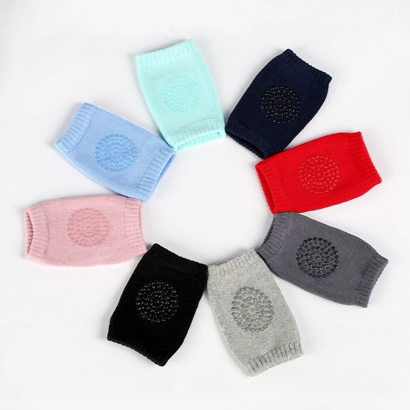 Assorted color Comfort Crawl baby knee pads with circular anti-slip grips arranged in circle.