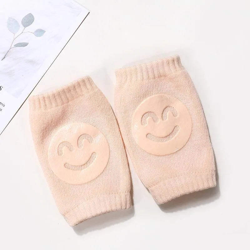 Peach Comfort Crawl baby knee pads with smiley grip pads on white background with leaf print.