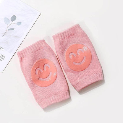 Pink Comfort Crawl baby knee pads with smiley grip pads for crawling support.