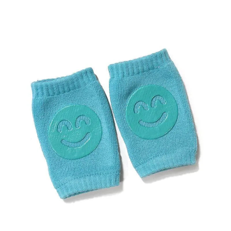 Turquoise Comfort Crawl baby knee pads with smiley grip pads for crawling protection.