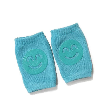 Turquoise Comfort Crawl baby knee pads with smiley grip pads for crawling protection.