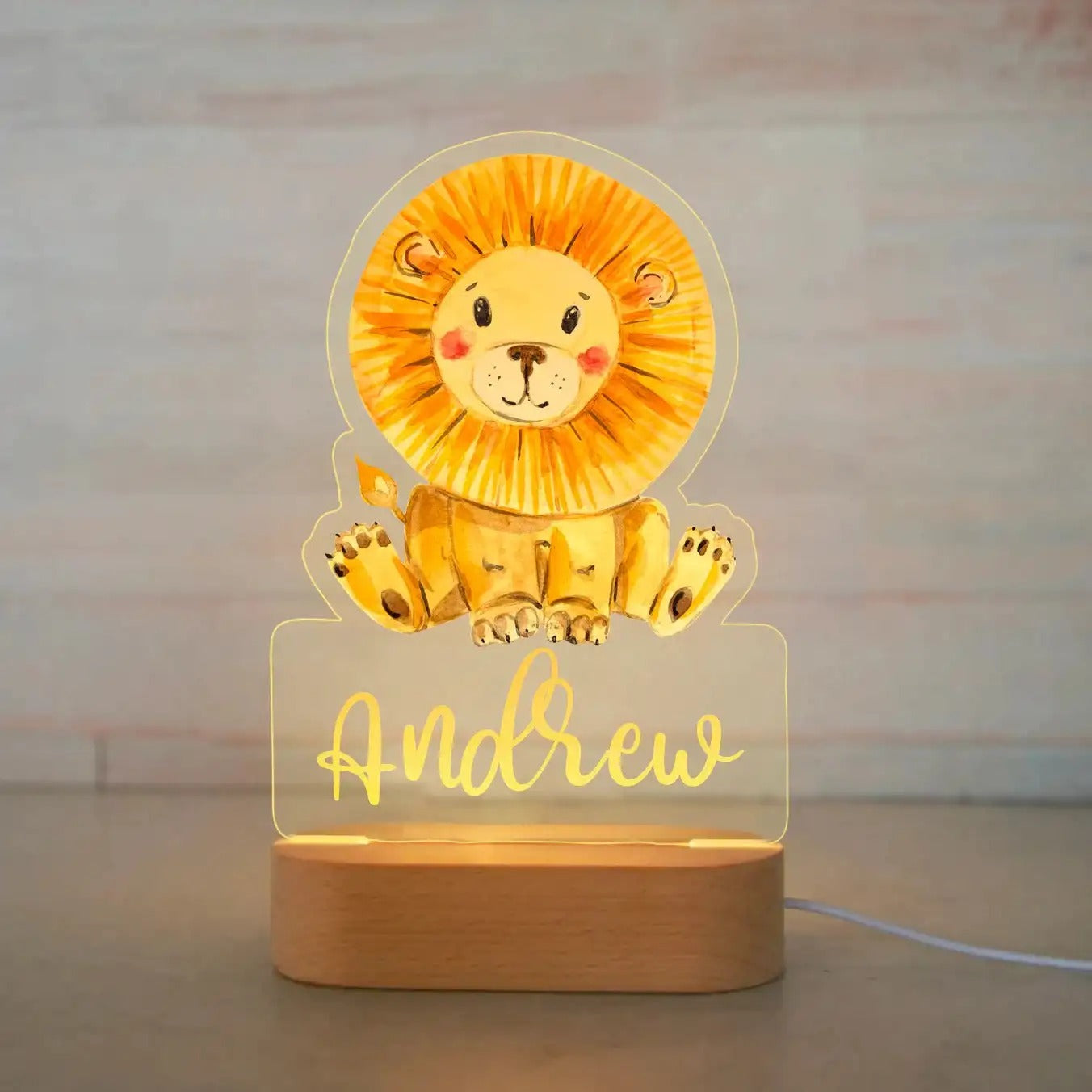 Lion cartoon personalized baby night light with name Andrew on wooden base.