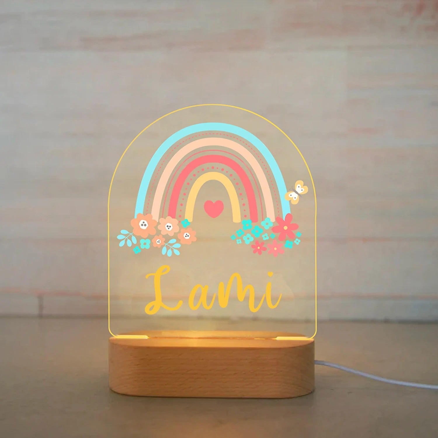Personalized rainbow and flower LED baby night light with name Lami on wooden base.