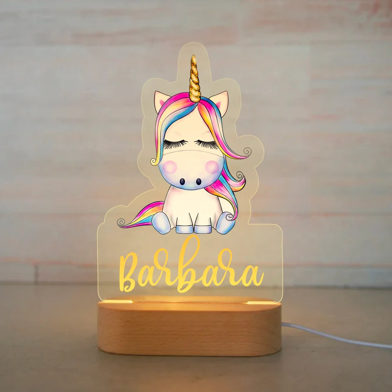 Personalized baby night light with cartoon unicorn and rainbow mane, custom name Barbara, on wooden base.