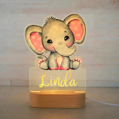 Gray elephant baby night light with pink ears and personalized name Linda on wooden base.